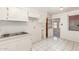 Functional kitchen featuring white cabinets and a stove top, leading to another room at 4553 N 54Th Ave, Phoenix, AZ 85031