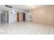 Open living room with white tile, wood paneling, and a view of the kitchen at 4553 N 54Th Ave, Phoenix, AZ 85031