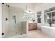 Modern bathroom featuring a frameless glass shower, soaking tub, and a wood vanity at 5426 E Karen Dr, Scottsdale, AZ 85254