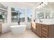 Bright bathroom with a soaking tub, and a stylish wood vanity with sleek countertops at 5426 E Karen Dr, Scottsdale, AZ 85254