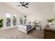 Bright bedroom with gray carpet, ceiling fan, and poolside view through glass patio doors at 5426 E Karen Dr, Scottsdale, AZ 85254