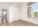 Bright bedroom with a large window, wood-look flooring, and closet with sliding doors at 5426 E Karen Dr, Scottsdale, AZ 85254