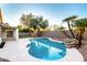 Backyard pool area with mature trees, a stone waterfall feature, and a spacious patio at 5426 E Karen Dr, Scottsdale, AZ 85254