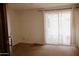 Bright bedroom with carpet flooring and sliding doors covered with decorative sheer curtains for privacy at 5602 W Heatherbrae Dr, Phoenix, AZ 85031