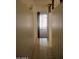 Hallway featuring tiled floors with a vintage wall sconce and doorway to a bright, carpeted room at 5602 W Heatherbrae Dr, Phoenix, AZ 85031