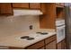 Kitchen with white cooktop, built-in oven and ample wooden cabinets for storage at 5602 W Heatherbrae Dr, Phoenix, AZ 85031