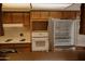 A kitchen featuring stainless steel refrigerator, white appliances, and wood cabinetry at 5602 W Heatherbrae Dr, Phoenix, AZ 85031