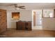 Open-concept living room with brick fireplace, ceiling fan, and small bar area at 5602 W Heatherbrae Dr, Phoenix, AZ 85031