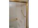 Shower with white tiles, gold trim, gold grab bars and a built-in step for convenience and safety at 5602 W Heatherbrae Dr, Phoenix, AZ 85031