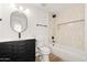 Modern bathroom boasts black fixtures, wood-look floors, and a shower over tub combination at 5951 W Granada Rd, Phoenix, AZ 85035