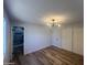 A bedroom featuring wood flooring, modern lighting, closet doors, and a view to the bathroom at 5951 W Granada Rd, Phoenix, AZ 85035