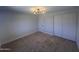A bedroom with carpet flooring, modern lighting, and closet doors at 5951 W Granada Rd, Phoenix, AZ 85035