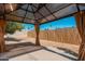 Gazebo with tan curtains overlooks the backyard with concrete patio and wood fence at 5951 W Granada Rd, Phoenix, AZ 85035