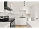 This modern kitchen features sleek white cabinetry, stainless steel appliances, and ample counter space for meal preparation at 5951 W Granada Rd, Phoenix, AZ 85035