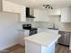 Bright kitchen with a kitchen island, stainless steel appliances, and white cabinets at 5951 W Granada Rd, Phoenix, AZ 85035