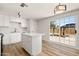 Bright kitchen with white cabinets, a center island, stainless steel appliances, and sliding glass doors to the backyard at 5951 W Granada Rd, Phoenix, AZ 85035
