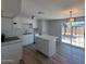 A bright kitchen features a kitchen island, wood flooring, white cabinets and stainless steel appliances at 5951 W Granada Rd, Phoenix, AZ 85035