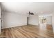 Bright living room with hardwood floors and a ceiling fan that connects to the kitchen at 5951 W Granada Rd, Phoenix, AZ 85035