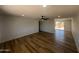 A bright living room with wood flooring, a ceiling fan, and an open kitchen in the background at 5951 W Granada Rd, Phoenix, AZ 85035