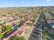 An aerial view of a neighborhood set against a mountain backdrop, showcasing tree-lined streets and red-tiled roofs at 6805 S 14Th St, Phoenix, AZ 85042