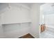 Walk-in closet leading to a full bathroom that features shelving, carpeted floor, and ample space for storage at 6805 S 14Th St, Phoenix, AZ 85042