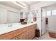 Bright bathroom featuring double sinks with wood cabinets, neutral tile and decorative mirrors at 705 W Queen Creek Rd # 2062, Chandler, AZ 85248