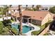 Back of beige home with a terracotta roof, covered patio, artificial grass, gorgeous pool, and lush landscaping at 786 E Coconino Dr, Chandler, AZ 85249