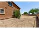 An expansive backyard with a two-story house is mostly dirt and has green trees at 833 S 113Th Ave, Avondale, AZ 85323