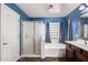 Bathroom with white shower, tub with jacuzzi, and vanity with blue walls and tiled floor at 833 S 113Th Ave, Avondale, AZ 85323