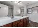Bright bathroom featuring double sinks, vanity, and a shower with glass door at 833 S 113Th Ave, Avondale, AZ 85323