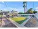Spacious backyard with lush artificial lawn, built in BBQ, inground pool, and shade structure at 908 E State Ave, Phoenix, AZ 85020