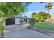 Traditional home with a well-kept lawn, mature trees, and a paved driveway leading to a garage at 908 E State Ave, Phoenix, AZ 85020