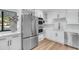 Modern white kitchen featuring stainless steel appliances, a wine rack, and a tile backsplash at 908 E State Ave, Phoenix, AZ 85020