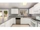 Bright kitchen with white cabinetry, granite counters, stainless dishwasher and eat-in bar at 10115 W Turney Ave, Phoenix, AZ 85037