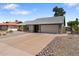 View of the front of the house, featuring a desert rock garden and long driveway leading to a two car garage at 10410 W Royal Palm Rd --, Peoria, AZ 85345
