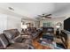 Open concept living room featuring stylish leather couches, wood floors, and a ceiling fan at 10410 W Royal Palm Rd --, Peoria, AZ 85345