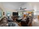 Spacious living room with wood floors, leather couches, ceiling fan, and sliding glass doors to backyard at 10410 W Royal Palm Rd --, Peoria, AZ 85345