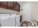 Efficient laundry room with washer, dryer, sink, and dark wood cabinets for storage at 10713 N 124Th Pl, Scottsdale, AZ 85259