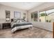 Bright main bedroom featuring wood-look tile flooring and large windows offering views of the outdoors at 10713 N 124Th Pl, Scottsdale, AZ 85259