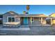 Charming single-story home featuring a covered porch and a bright blue front door at 11014 W Cocopah St, Avondale, AZ 85323