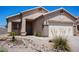 Charming single-story home featuring a well-maintained front yard with desert landscaping and a two-car garage at 1102 N 5Th St, Buckeye, AZ 85326