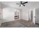 Bright main bedroom with carpeted flooring, a ceiling fan, and en-suite bathroom with an open doorway at 1102 N 5Th St, Buckeye, AZ 85326