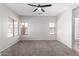 Spacious main bedroom features plush carpet, a ceiling fan, two windows, and an en-suite bathroom at 1102 N 5Th St, Buckeye, AZ 85326