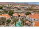An aerial view of the community featuring a pool, palm trees, and nearby commercial areas in a picturesque setting at 11375 E Sahuaro Dr # 2033, Scottsdale, AZ 85259