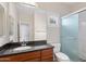 Bathroom with granite countertop vanity, a large mirror, and a walk-in shower with glass doors at 11375 E Sahuaro Dr # 2033, Scottsdale, AZ 85259