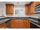 Kitchen featuring stainless steel appliances, granite countertops, and wood cabinetry at 11375 E Sahuaro Dr # 2033, Scottsdale, AZ 85259