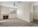 Bright living room with a fireplace, neutral carpet, and ceiling fan at 11375 E Sahuaro Dr # 2033, Scottsdale, AZ 85259