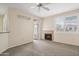 Living room with fireplace, neutral carpet, ceiling fan, and natural light at 11375 E Sahuaro Dr # 2033, Scottsdale, AZ 85259