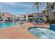 Community pool area with a spa, seating, and lush landscaping on a sunny day at 11375 E Sahuaro Dr # 2033, Scottsdale, AZ 85259