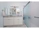 Bright bathroom boasts a double sink vanity, large mirror, and frosted glass shower at 11580 N 86Th Ln, Peoria, AZ 85345